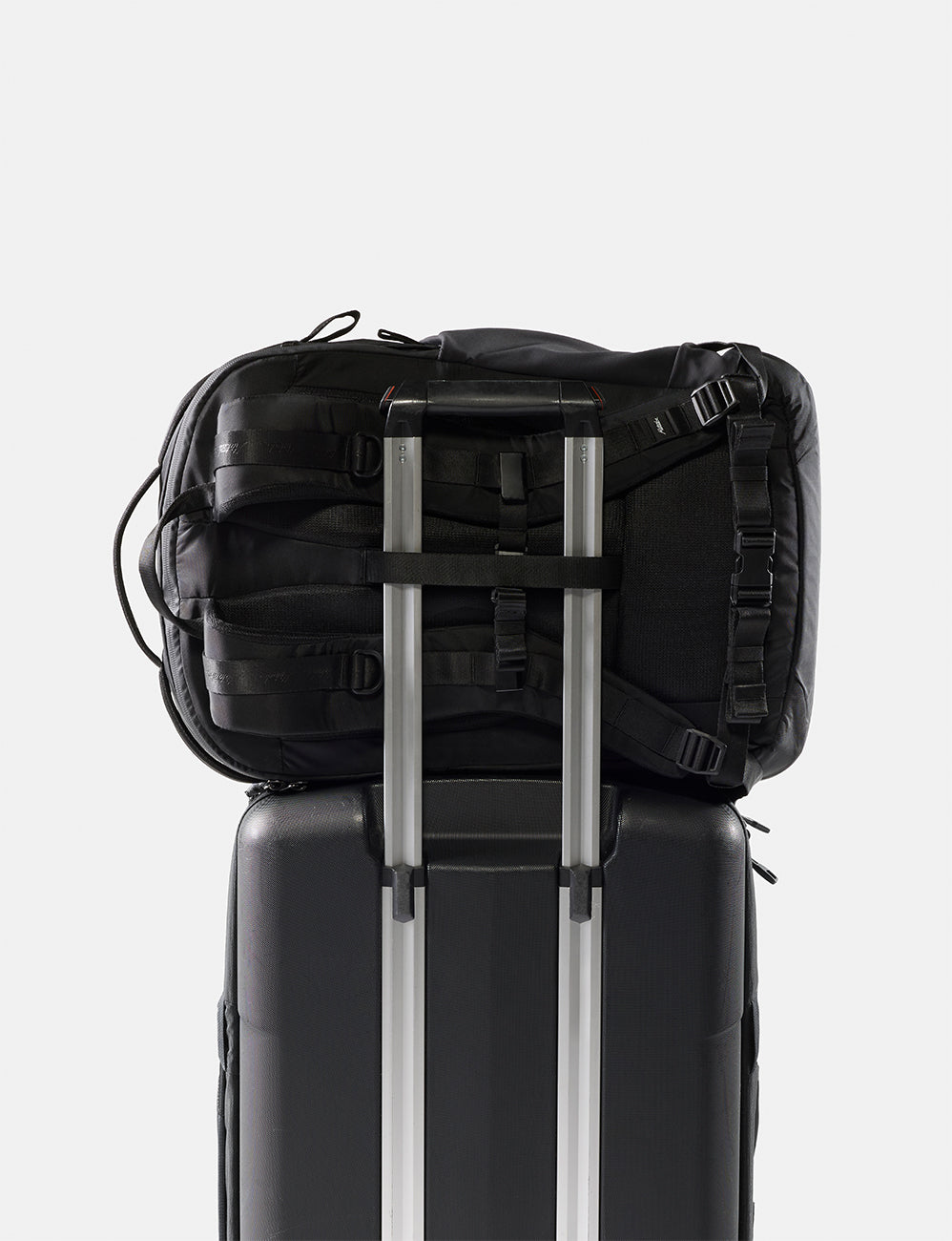Matador 30L Carry-On Travel Pack in Black - black backpack on top of a black suitcase with a white background