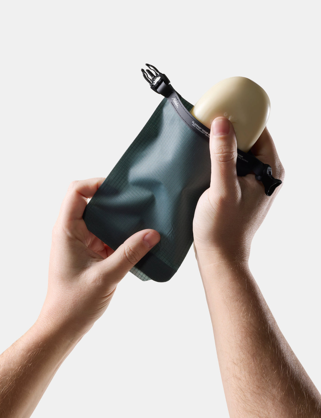 Matador FlatPak Travel Soap Bar Case (V2) in Juniper - person holding Blue-green soap bar case and soap on a light background
