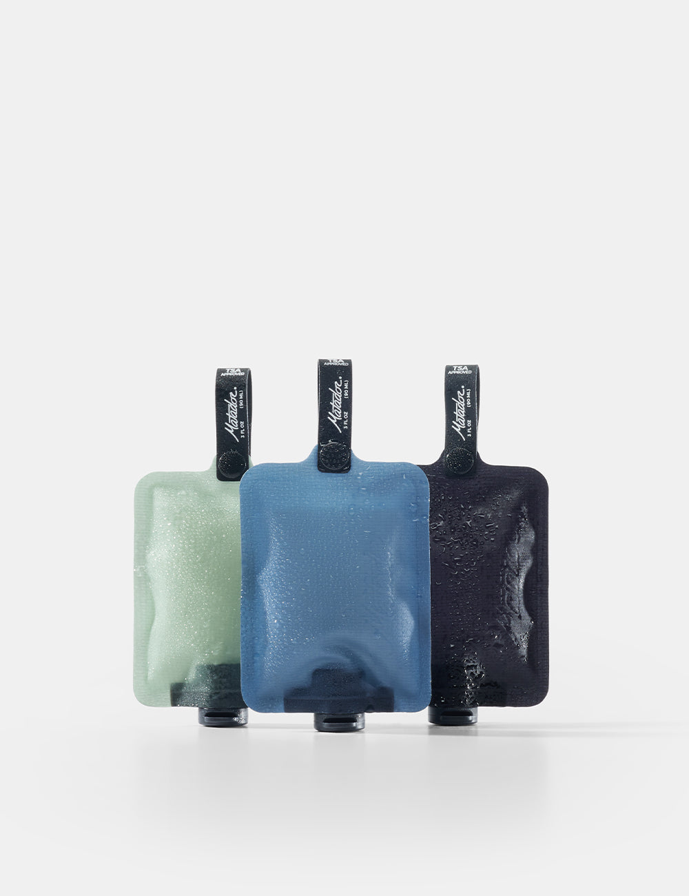 Matador FlatPak™ Toiletry Bottles - 3 Pack (Multi-Colour) - three toiletry bottles in green, blue, and black on a white background
