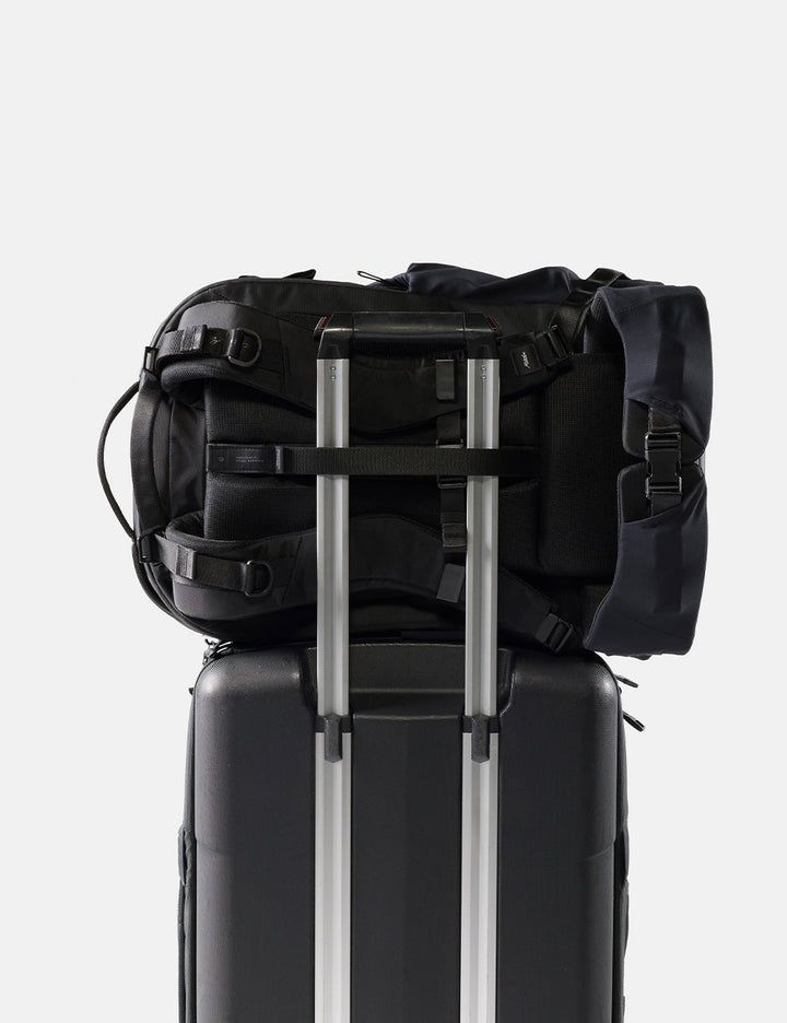 Matador 35L Global Travel Pack in Black - black backpack on top of a black suitcase with a white background
