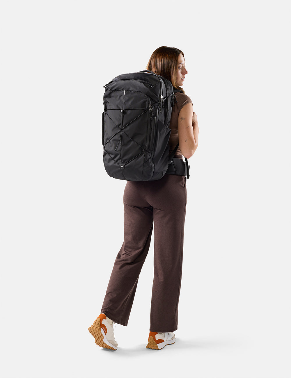 Matador 45L Global Travel Pack in Black - person wearing a large black backpack on a white background