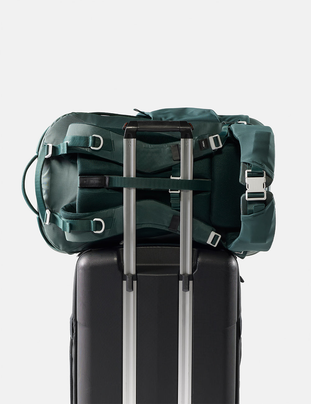 Matador 45L Global Travel Pack in Juniper - green backpack on top of a black suitcase with a white background