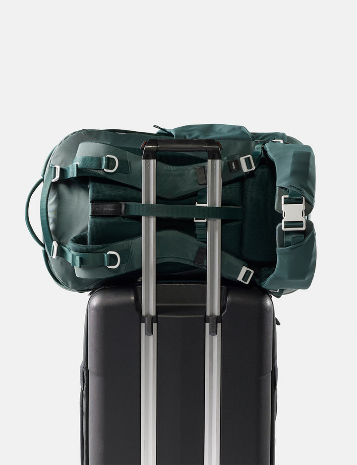 Matador 45L Global Travel Pack in Juniper - green backpack on top of a black suitcase with a white background