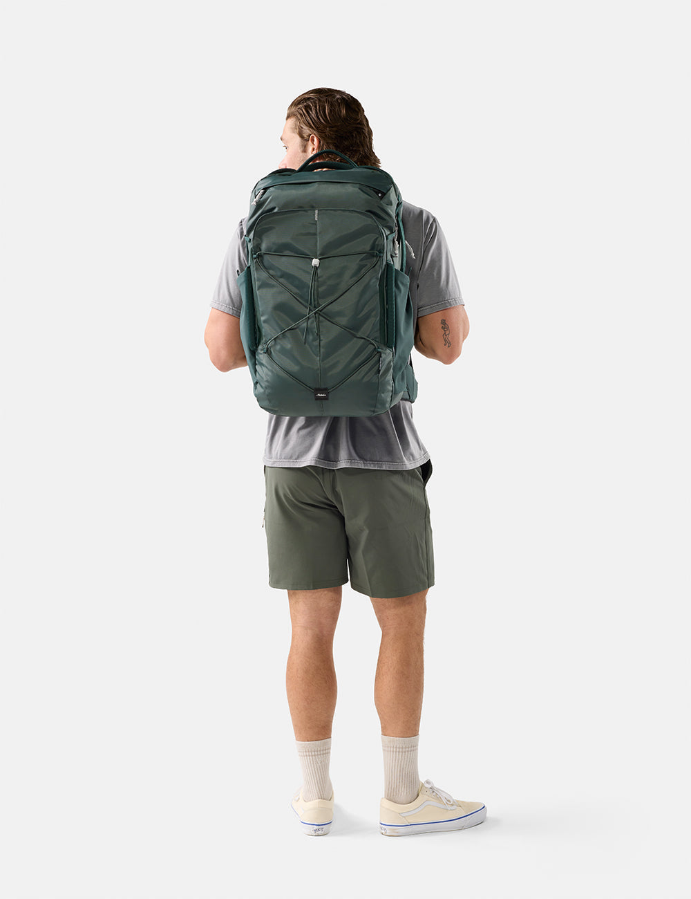 Matador 45L Global Travel Pack in Juniper - person wearing a green backpack on a white background