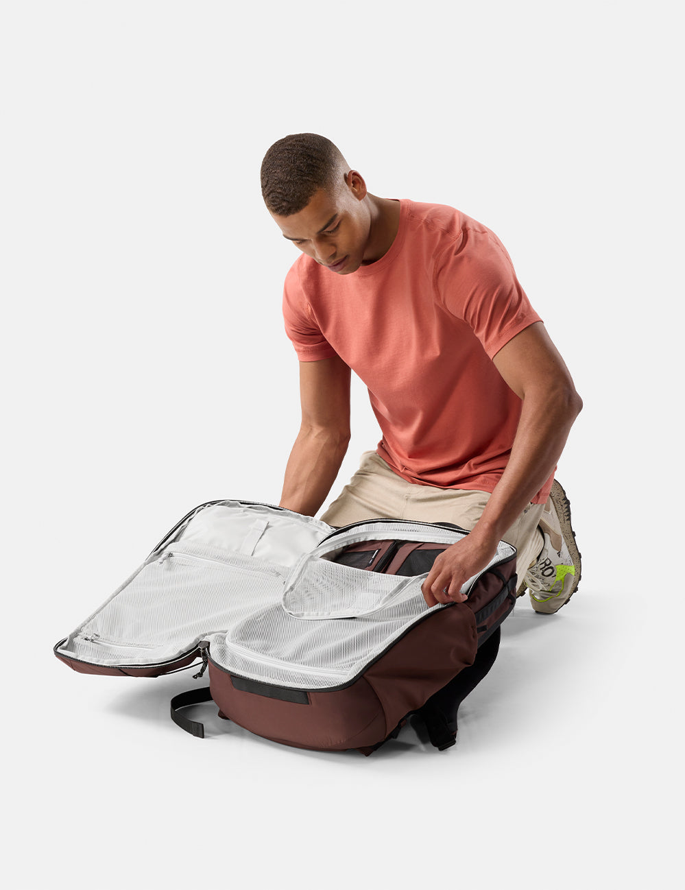 Matador 45L Global Travel Pack in Garnet - man unpacking a large garnet backpack on a white background