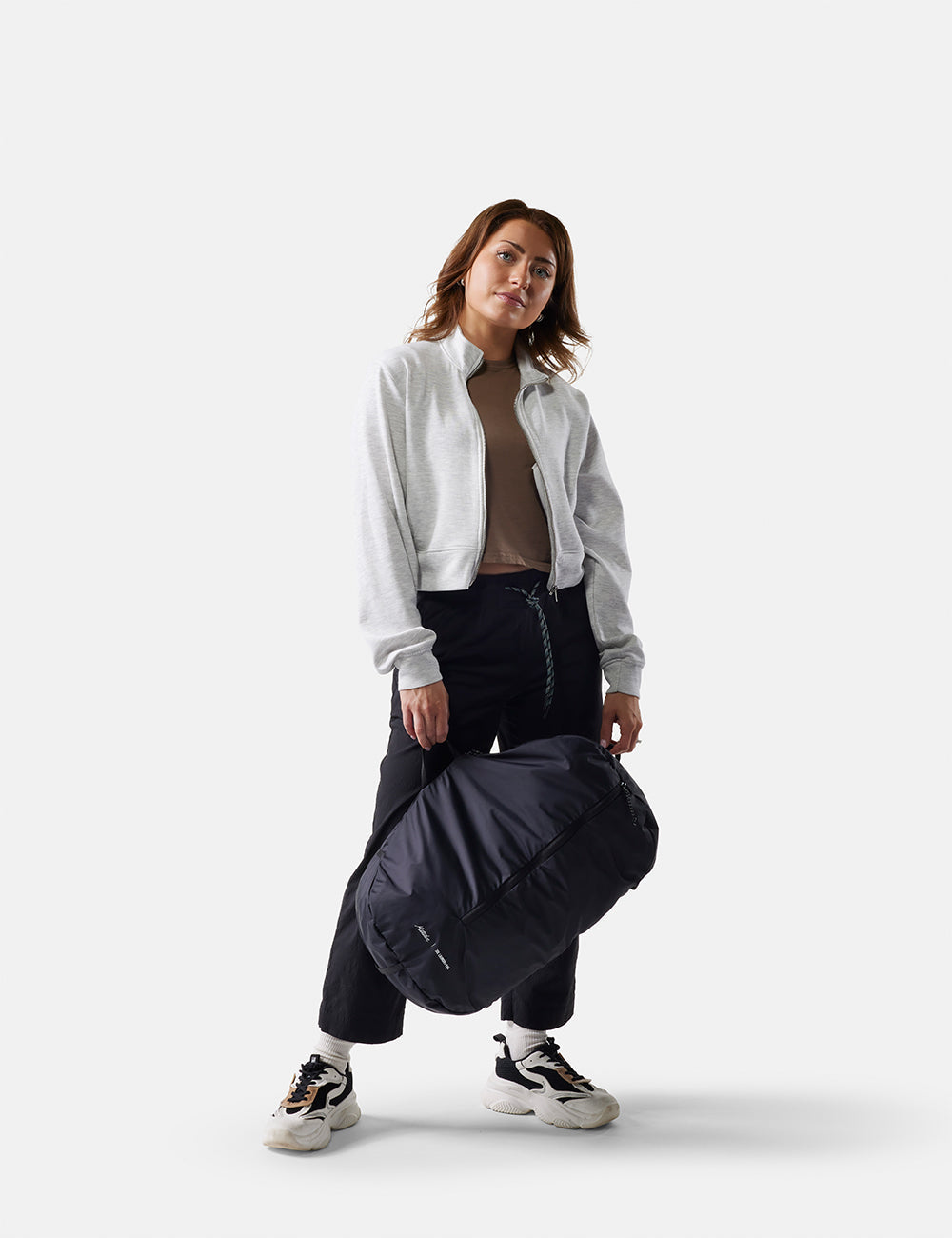 Matador Packable Laundry Bag - woman holding a black laundry bag against a white background