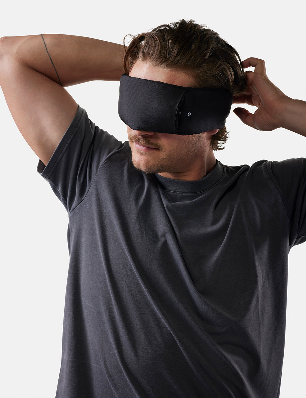 Matador Blackout Eyemask + Earplugs Kit - man wearing a black sleep mask against a plain background