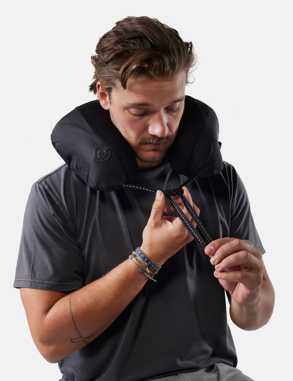 Matador Blackout Travel Pillow - man wearing a black neck pillow against a white background