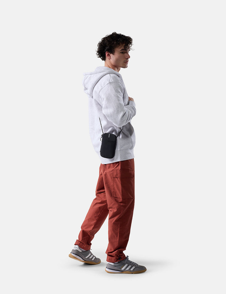 Matador Global Travel Stash in Black - man on white background wearing travel wallet cross body