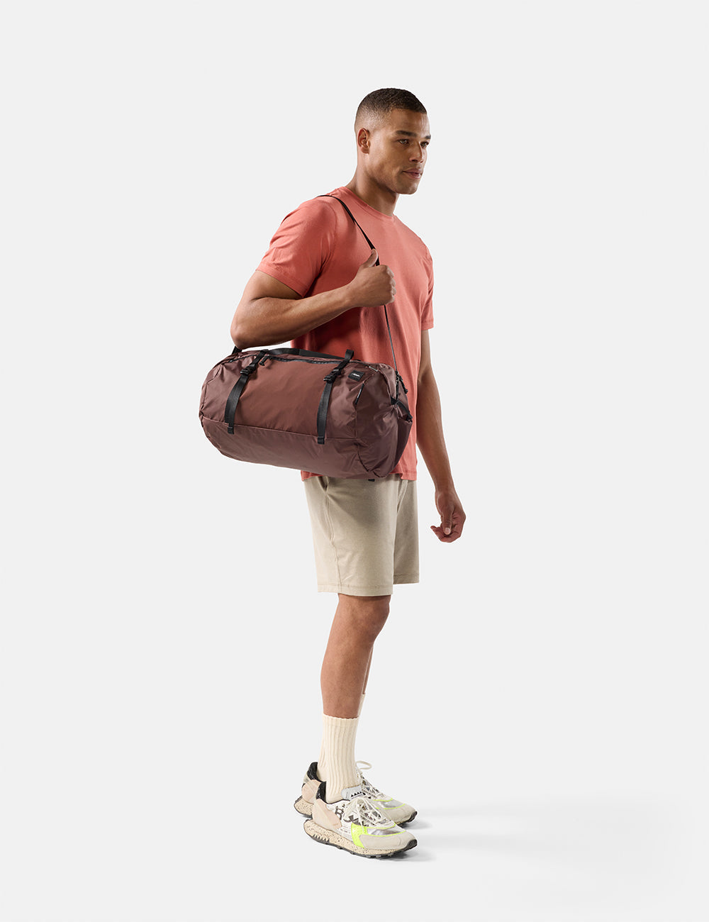 Matador 30L Packable Duffel in Garnet - man holding a duffel bag on a white background
