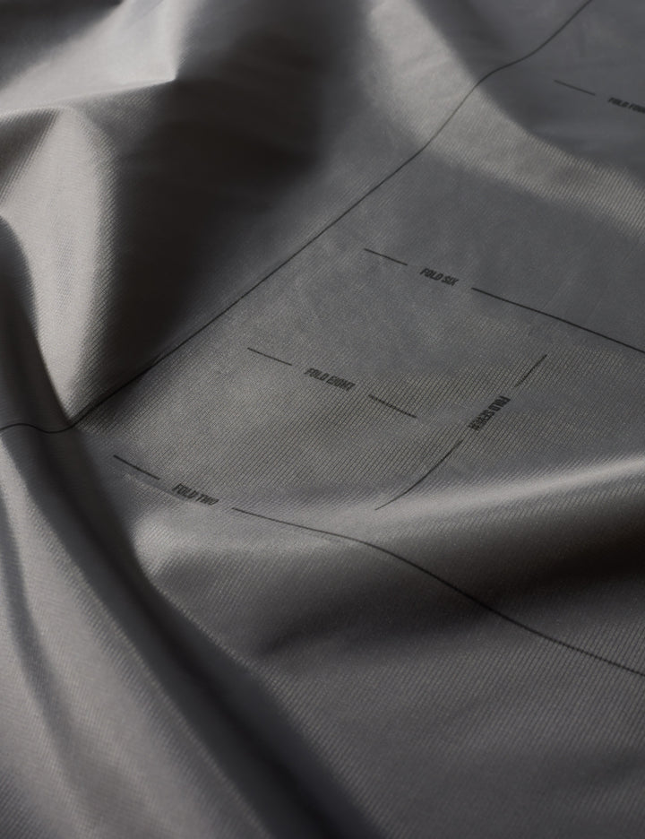 Matador Mini Pocket Blanket™ 4.0 - 110 x 70cm in Black - close-up of gray fabric with subtle texture and folds