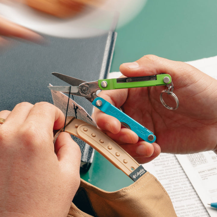 Leatherman Micra - Teal Twist scissors snipping a price tag thread - Nitecore Singapore