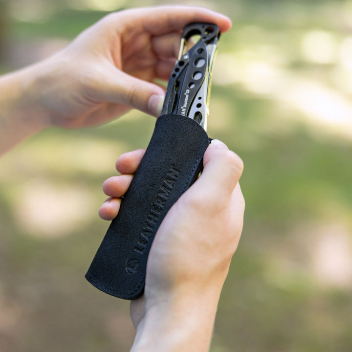 Leatherman Leather Sleeve - sliding a multi-tool into the black sleeve - Nitecore Singapore